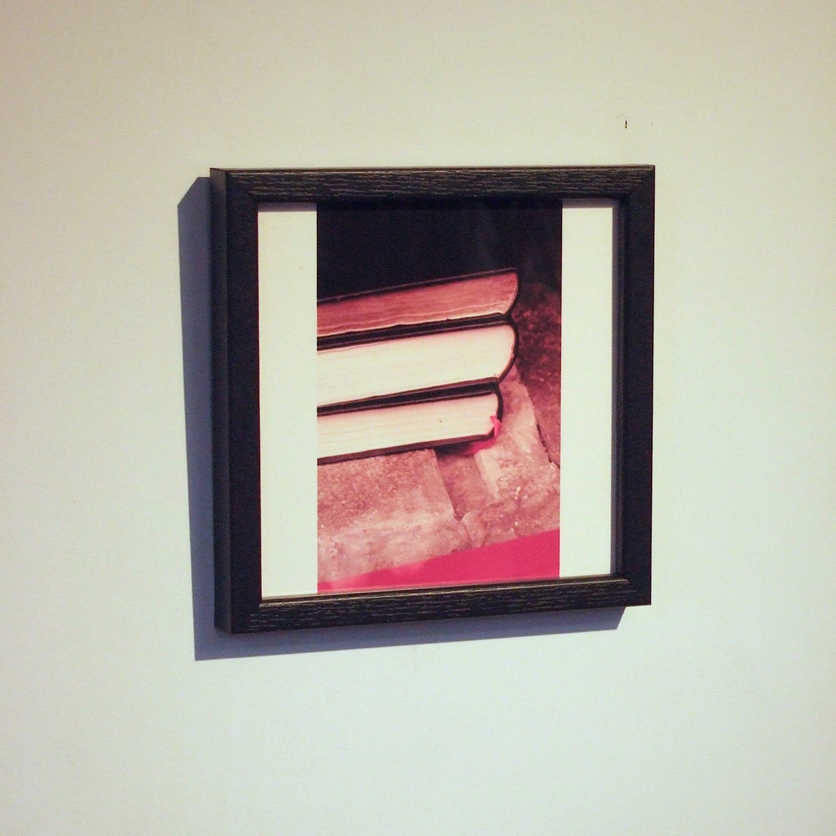 黒のウッドフレームで額装して白い壁面に飾る