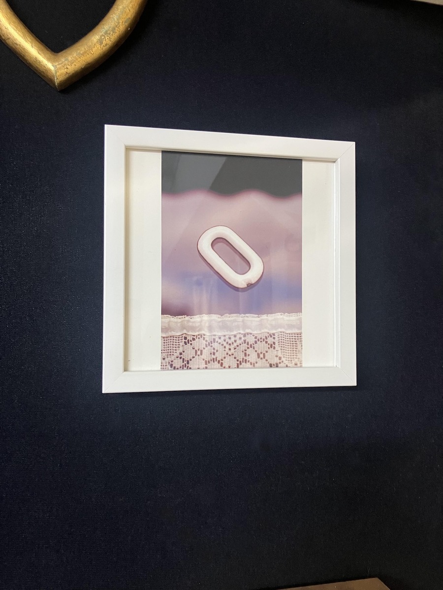 白い額縁で額装して黒の壁面に飾る